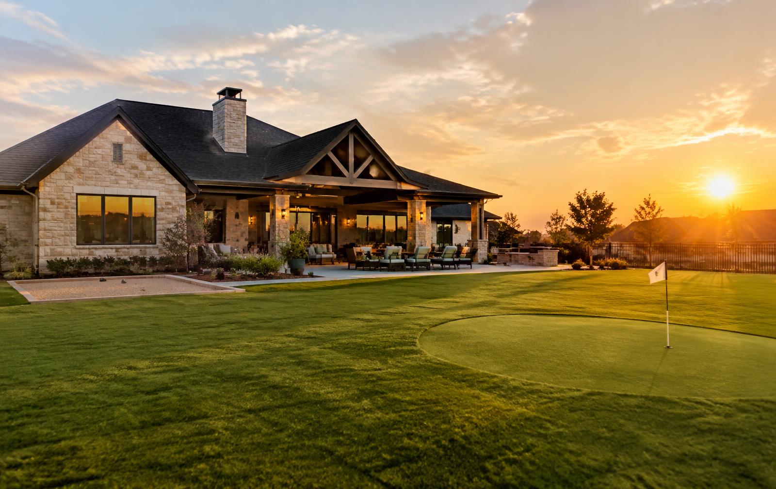 Golden-hour backyard with turf lawn and putting green